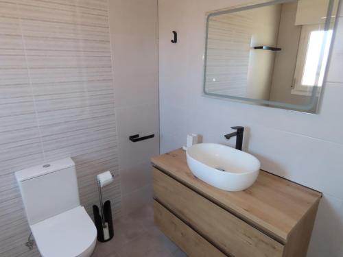 uma casa de banho com um WC branco e um lavatório. em Villa Descansa em Ciudad Quesada