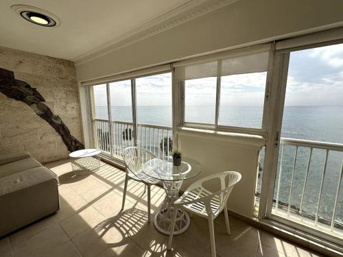 a living room with a table and chairs on a balcony at Villa Marbella by Potenza Rentals in Santo Domingo