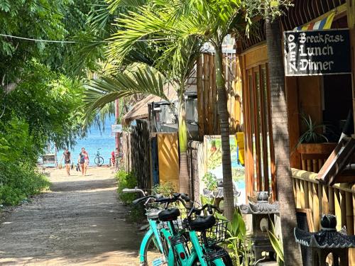 two bikes parked outside of a building next to the beach at Sunny Rose Bungalows Gili Air - Adults only in Gili Air