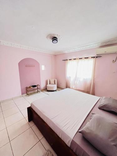 a large bedroom with a large bed and a chair at Dubaï to Conakry KIPE in Conakry