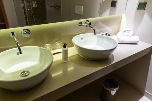 a bathroom with a white sink and a mirror at Avenida Boutique Hotel in Viseu