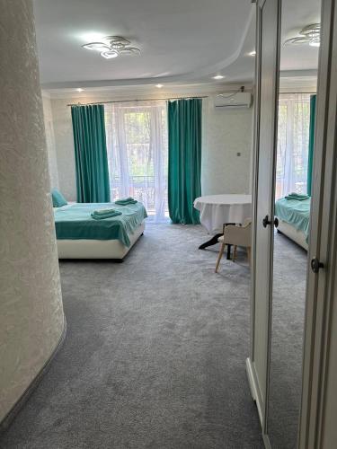 a room with two beds and a table in it at Готель-спа "Еліт" in Kolʼchyno