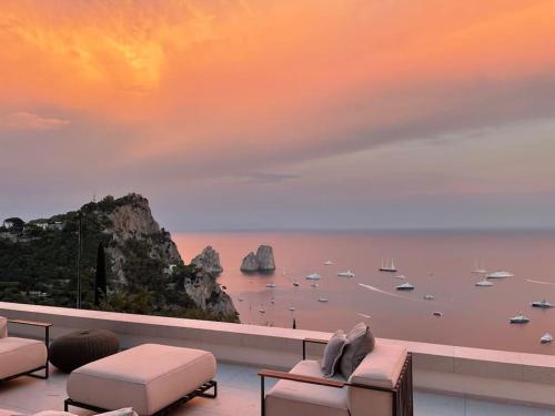 Un balcón con sillas y vistas al océano. en Villa le gradelle with amazing view en Capri