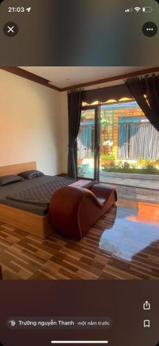 ein Schlafzimmer mit einem großen Bett und einem großen Fenster in der Unterkunft Khu du lịch sinh thái Đăk rơ wa in Kon Tum