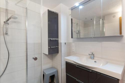 a bathroom with a sink and a shower with a mirror at Urlaub Im Häusle in Loßburg