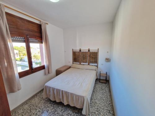 um quarto com uma cama e uma janela em APARTAMENTO SANT MORI-3 em Empuriabrava