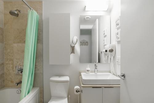 a bathroom with a sink and a toilet and a shower at Waterfront High Rise Condo Downtown in Toronto