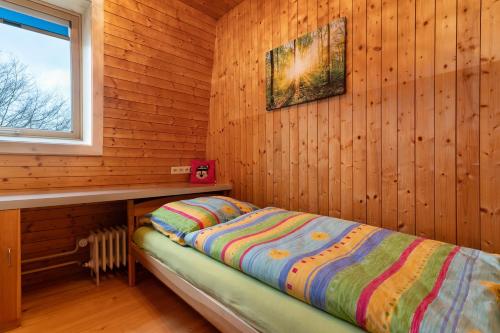 ein Schlafzimmer mit einem Bett in einer Holzhütte in der Unterkunft Urlaub Im Häusle in Loßburg