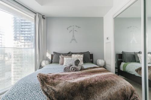a bedroom with two beds and a large window at Waterfront High Rise Condo Downtown in Toronto