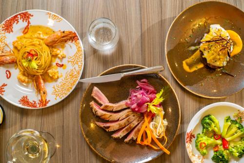 a wooden table with plates of food on it at Hotel Villaggio Cala Di Volpe in Capo Vaticano