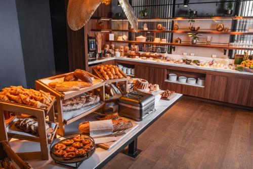 una panadería con muchos tipos diferentes de pan y repostería en Hôtel LÉONOR the place to live en Estrasburgo