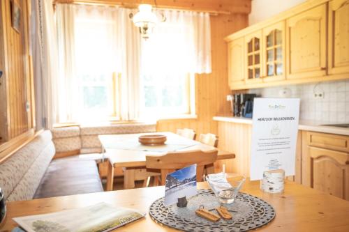 a kitchen with a table and a dining room with a table at Appartements Zettler in Donnersbachwald