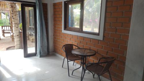 a table and chairs sitting next to a brick wall at Punta Pacífico Bungalows Máncora in Máncora