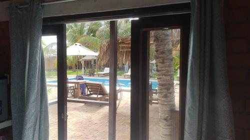 a sliding glass door leading to a swimming pool at Punta Pacífico Bungalows Máncora in Máncora