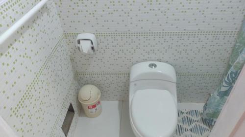 a small bathroom with a toilet and a trash can at Punta Pacífico Bungalows Máncora in Máncora