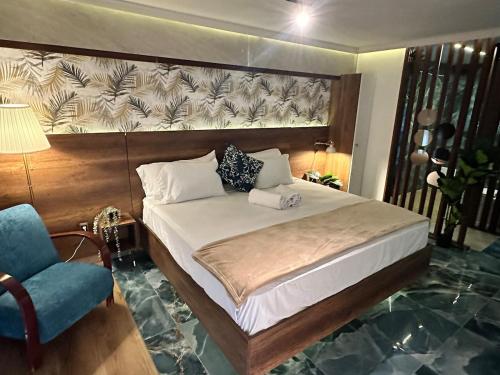 a bedroom with a large bed and a blue chair at Villa Marbella by Potenza Rentals in Santo Domingo