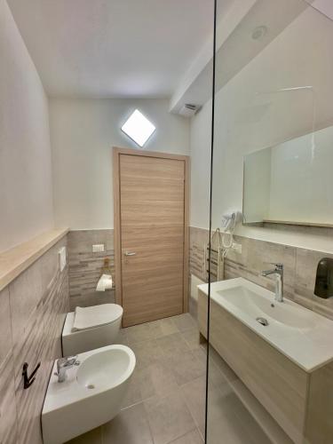 a bathroom with a sink and a toilet and a mirror at Casa del Mare in Bosa