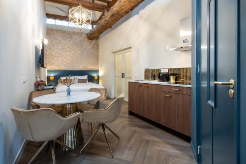 a kitchen with a table and chairs in a room at Grapèlli Boutique Hotel in Alkmaar