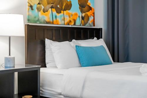 a bedroom with a white bed with a blue pillow at BCA Furnished Apartments in Atlanta
