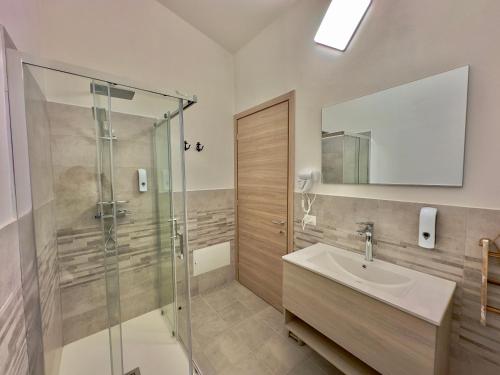 博薩的住宿－Casa del Mare Guest house，一间带玻璃淋浴和水槽的浴室