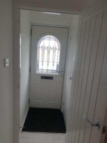 a white door with a window and a black rug at Greys room share in Warrington