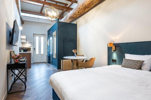 a bedroom with a large bed and a table at Grapèlli Boutique Hotel in Alkmaar