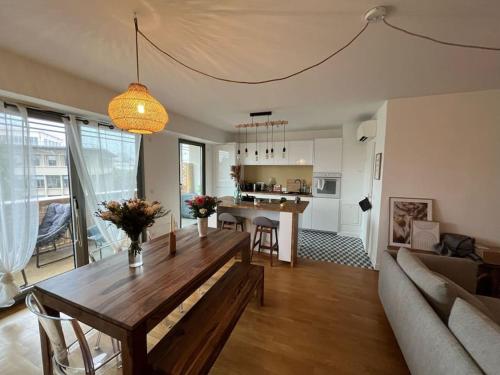 uma sala de estar com uma mesa de madeira e um sofá em Appartement 4pax : Parking, balcon, climatisation. em Boulogne-Billancourt