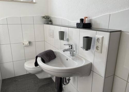 a white bathroom with a sink and a toilet at Lieblingsplatz in Pfullendorf