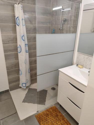 une salle de bain avec un rideau de douche et un lavabo dans l'établissement Maison moderne à Mimizan Idéale pour un séjour au calme, à Mimizan