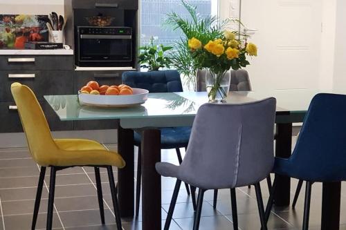 une cuisine avec une table et des chaises ainsi qu'un bol d'oranges dans l'établissement Maison moderne à Mimizan Idéale pour un séjour au calme, à Mimizan