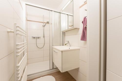 a white bathroom with a sink and a shower at Easyapartments Leo in Linz