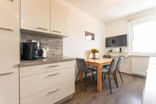 a kitchen with a table with chairs and a microwave at Easyapartments Leo in Linz