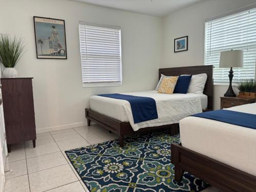 1 dormitorio con 2 camas y alfombra en Cozy 2 bedroom near intercoastal & beaches, en North Palm Beach