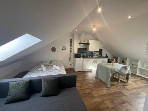 Zimmer mit einem Bett und einem Tisch sowie einer Küche in der Unterkunft Le garden cottage 20m² 2 personnes in Flers-lez-Lille