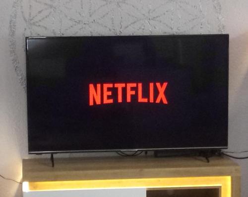 un écran de télévision avec les mots «netflix» dans l'établissement FeWo Blaue Oase, Netflix, Massagesessel, Whirlpool Badewanne, à Germersheim