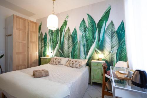 a bedroom with a mural of leaves on the wall at B&B La Volpina in Rimini