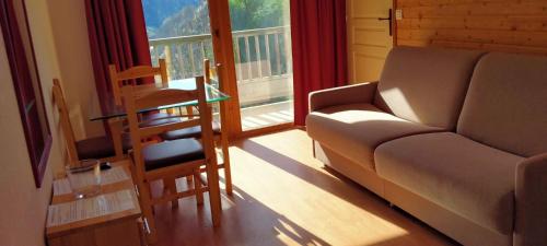 a living room with a couch and a chair and a window at Orelle 3 Vallées - 2 pièces 3 personnes in Orelle