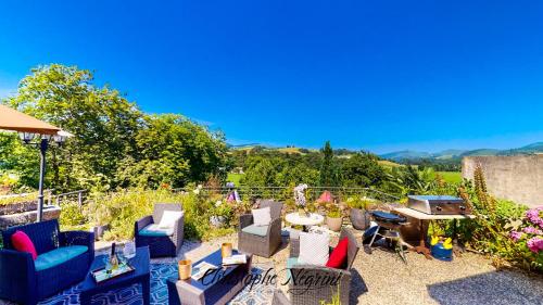 a patio with chairs and a table and a grill at Château Porthos Tranquillité des Pyrénées in Lanne en Barétous