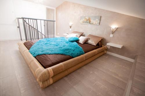um quarto com uma cama grande e um cobertor azul em Bulle d'eden em La Seyne-sur-Mer