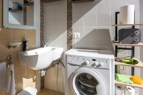 a bathroom with a washing machine and a sink at The Rising Sun in Marinella di Selinunte