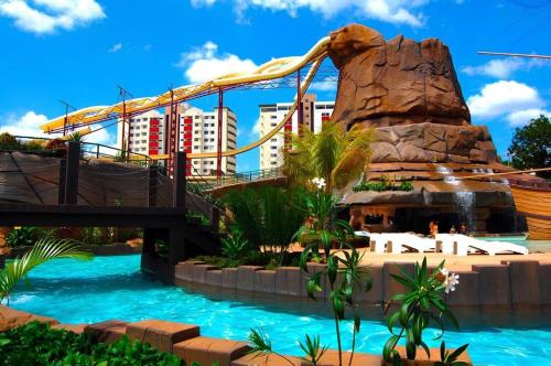 a water slide at a resort with a roller coaster at Spazzio Diroma Com acesso gratuito ao Acqua Park - R in Caldas Novas