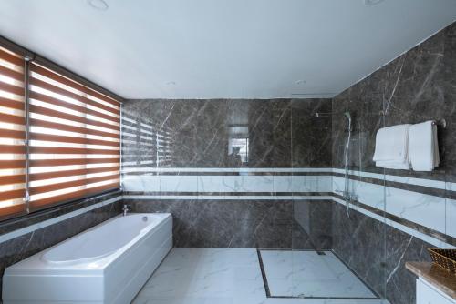 ein Bad mit einer Badewanne und einem WC in der Unterkunft Chuỗi Villa 6 Ngủ FLC - Bể bơi - Gara ô tô - Hạ Long in Hạ Long