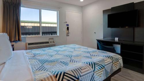 a bedroom with a bed and a flat screen tv at Motel 6-Eureka, CA Redwood Coast in Eureka