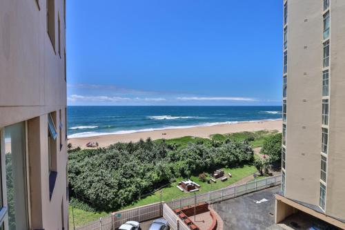 a view of the beach from the balcony of a building at Beach Bliss in Amanzimtoti