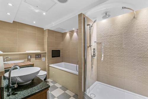 uma casa de banho com uma banheira, um WC e um lavatório. em Spa Hotel at Ribby Hall Village em Wrea Green