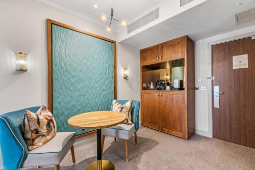 a room with a table and chairs and a kitchen at Spa Hotel at Ribby Hall Village in Wrea Green