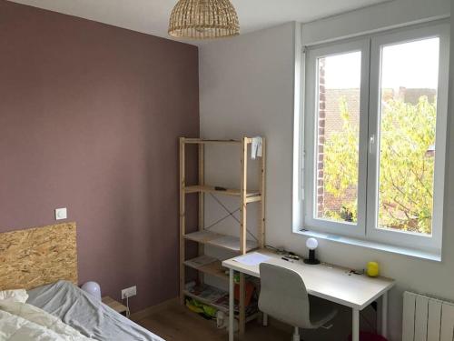 a bedroom with a desk and a bed and a window at Maison cosy au calme in Anzin