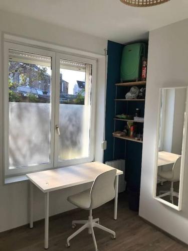 a desk and a chair in a room with a window at Maison cosy au calme in Anzin