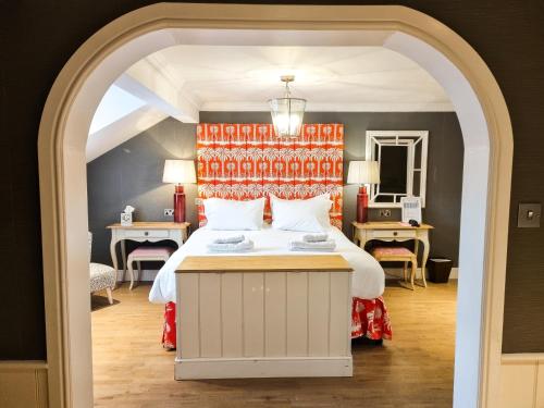 a bedroom with a white bed with an orange headboard at The Swan Hotel and Spa in Newby Bridge