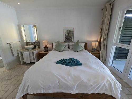 a large white bed with a blue towel on it at Maison La Plage by Simply-Seychelles in Eden Island